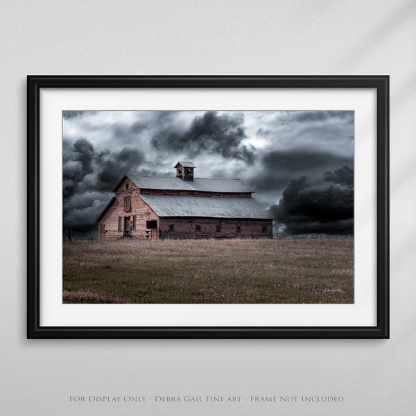 a framed photograph of a barn in a field