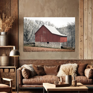 a large red barn in a snowy landscape, with a cozy living room setting in the foreground.