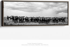A herd of cows standing in a field, captured in a black and white photograph.