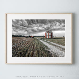 a black and white photo of a farm with a barn in the background