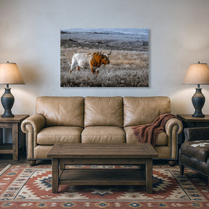 a large, brown leather couch in a living room setting, with a wooden coffee table in front of it. Above the couch, there is a framed photograph of a bull standing in a field.