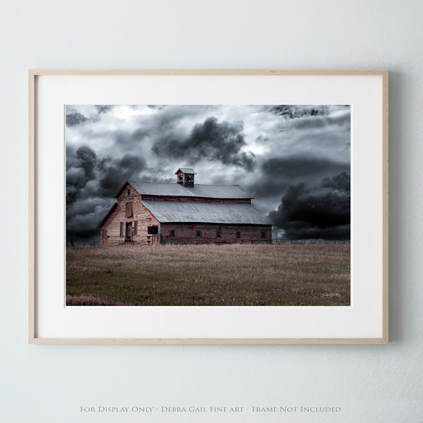 a picture of a barn in a field under a cloudy sky