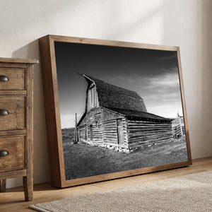 Black and white photograph of historic Mormon Row barn in Wyoming with dramatic sky and rustic wooden architecture.