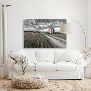 a living room with a white sofa, a coffee table, and a large painting of a farm scene hanging on the wall above the sofa.