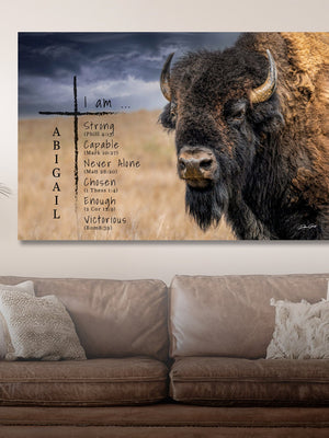 Canvas print with a bison and motivational text on a wall above a couch.