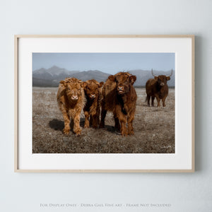 a group of brown cows standing on top of a dry grass field