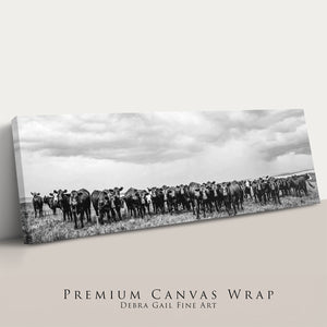 A herd of cows standing in a field, captured in a black and white photograph.