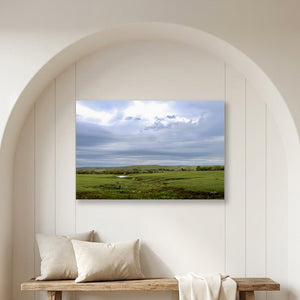 A Flint Hills Kansas fine art canvas print depicting a beautiful green field under a cloudy sky, by Debra Gail.